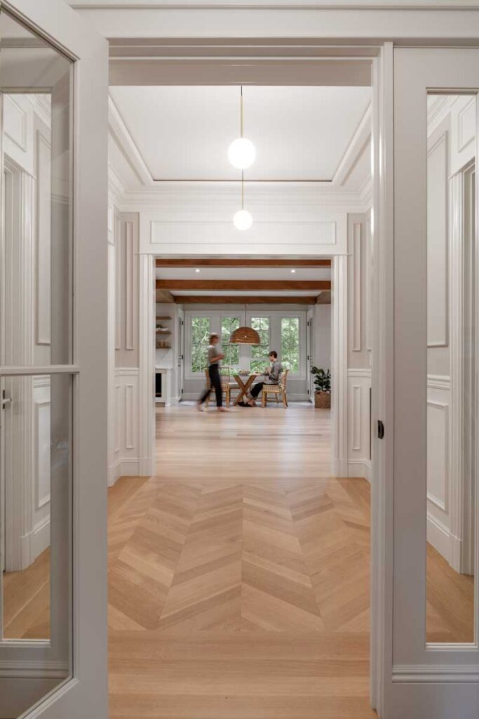 A hallway with white walls and wood floors, creating a clean and warm ambiance.